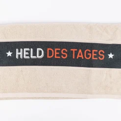 Badetuch aus Baumwolle Held des Tages beige schwarz weiß orange 70x140cm von La Vida